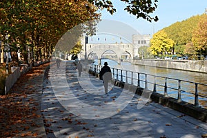 Promenade le long du quai Notre-Dame aÃÂ Tournai en Belgique en automne. Pont des trous en perspective photo